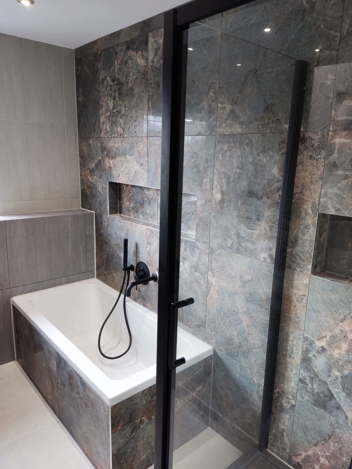 Luxury dark marble bathroom installation with black shower screen by Kings Renovations in Hertfordshire